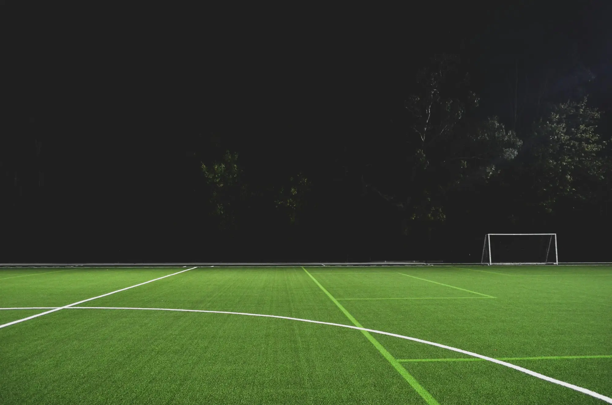 Cancha de césped sintético iluminada de noche