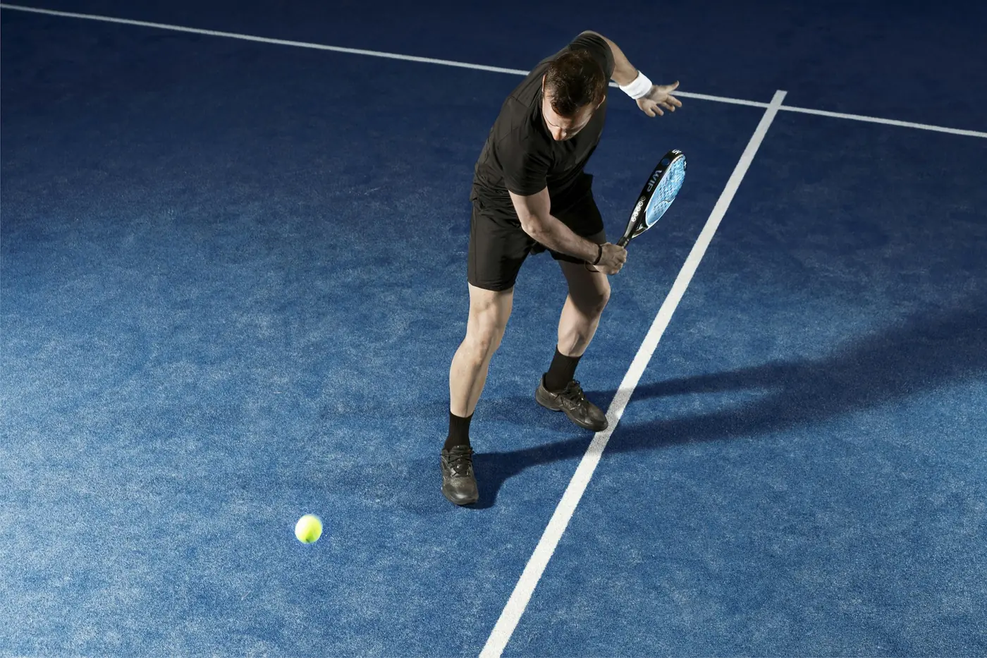 Jugador de pádel en una cancha azul